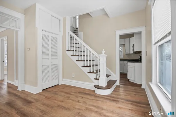 a view of entryway and hall with wooden floor