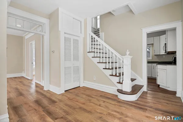 a view of entryway and hall with wooden floor