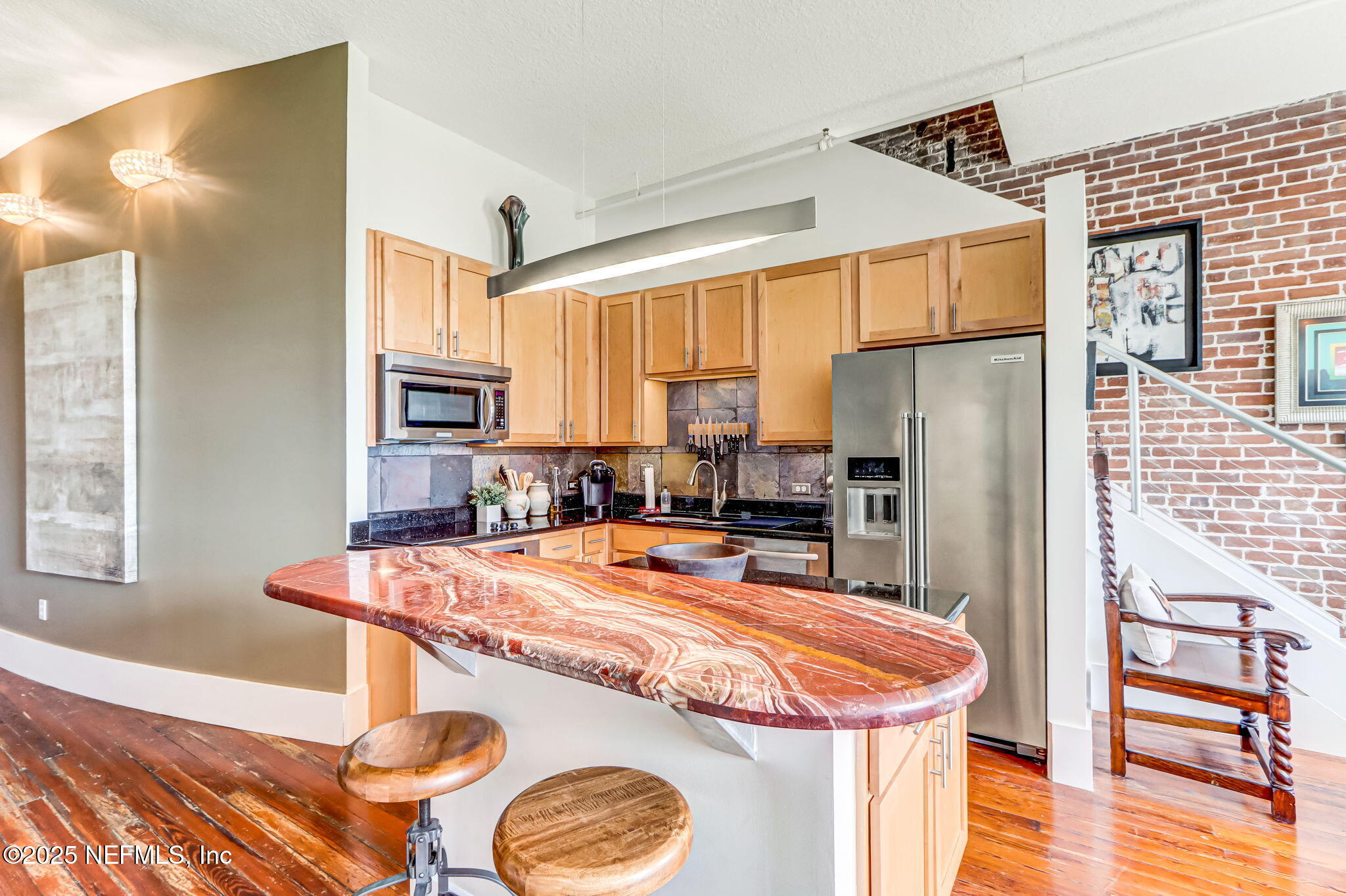 301 East Bay Street, Unit 405 Jacksonville, FL 32202 - Photo 11 of 42 a kitchen with stainless steel appliances granite countertop a refrigerator a stove and white cabinets with wooden floor