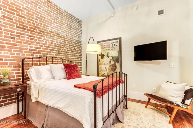 a bedroom with a bed next to a window