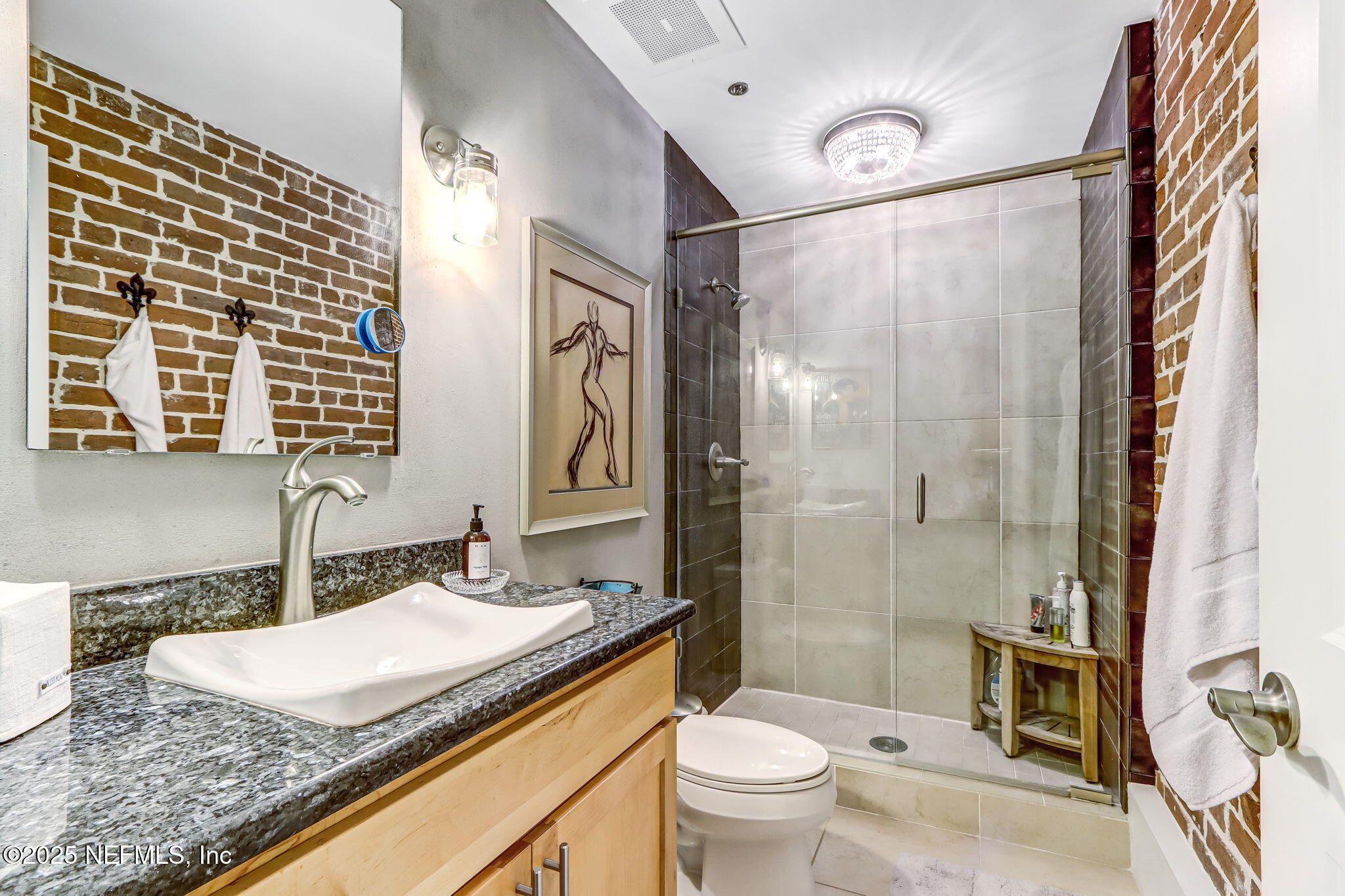 301 East Bay Street, Unit 405 Jacksonville, FL 32202 - Photo 19 of 42 a bathroom with a granite countertop sink toilet and shower