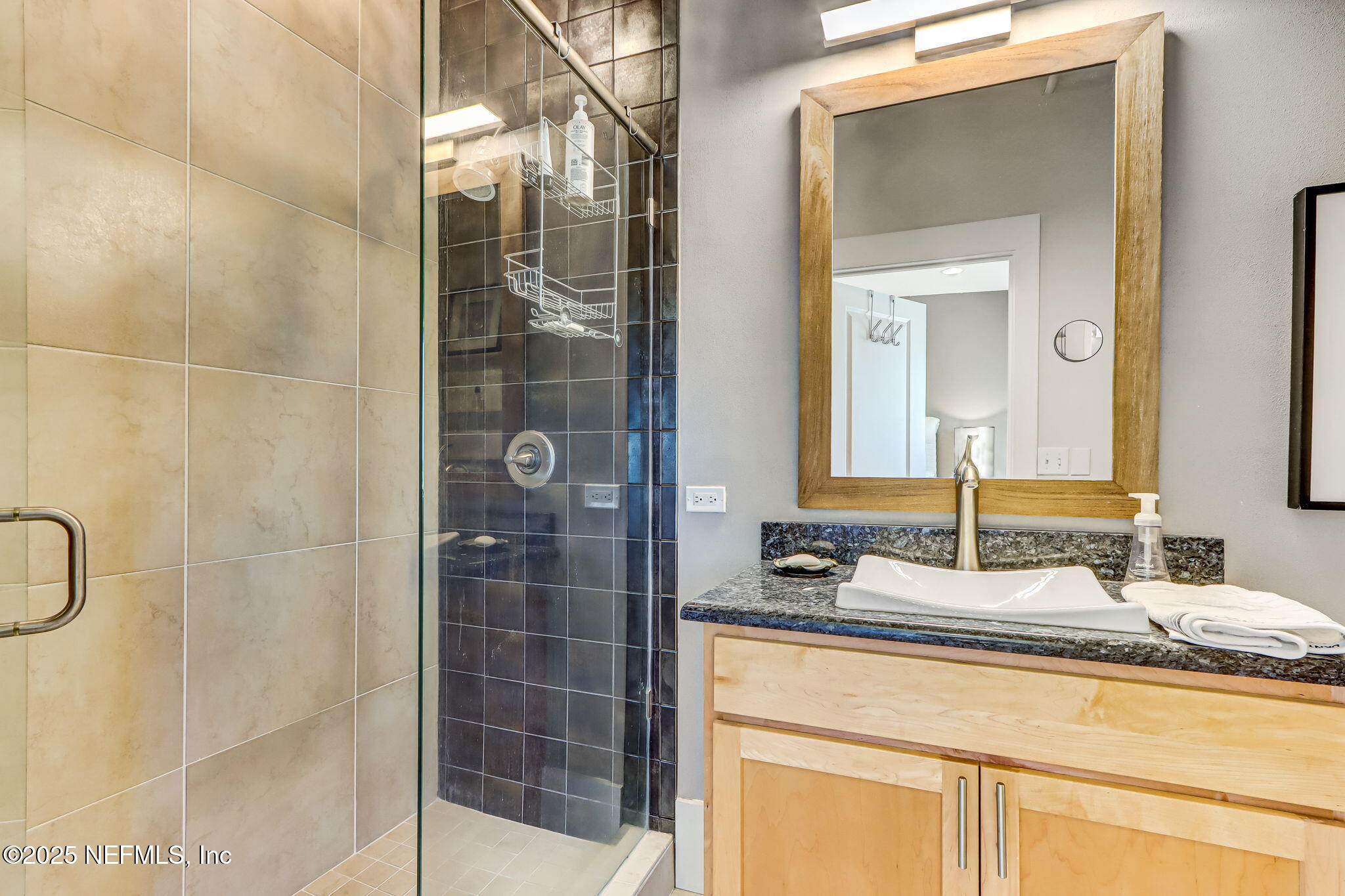 301 East Bay Street, Unit 405 Jacksonville, FL 32202 - Photo 29 of 42 a bathroom with a granite countertop sink a mirror and shower