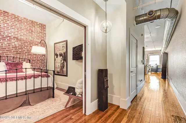a hallway with a view of living room with wooden floor