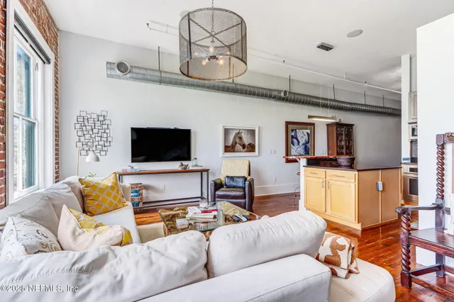 a living room with furniture a flat screen tv and kitchen view