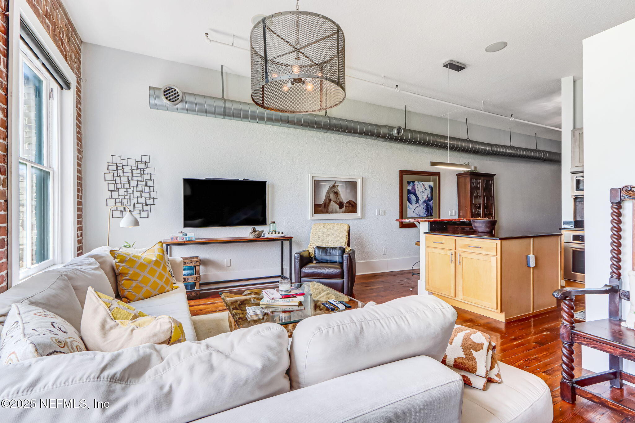 301 East Bay Street, Unit 405 Jacksonville, FL 32202 - Photo 4 of 42 a living room with furniture a flat screen tv and kitchen view