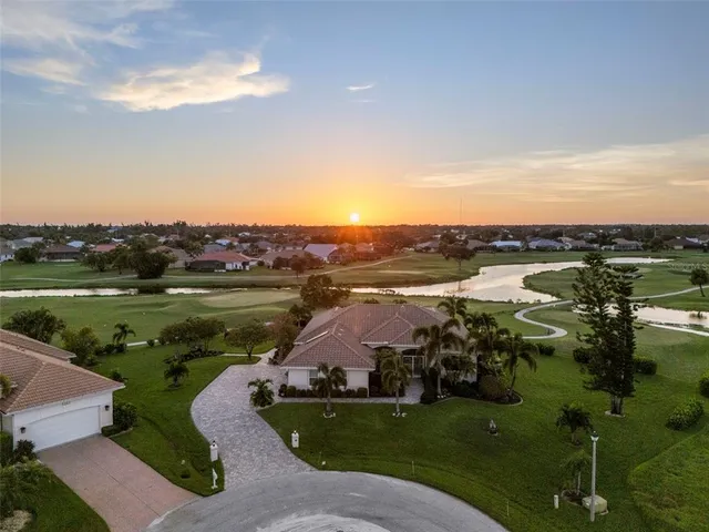 an aerial view of a house with outdoor space swimming pool and lake view in back