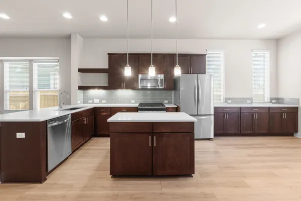 a kitchen with stainless steel appliances granite countertop a stove a sink dishwasher a refrigerator and a oven