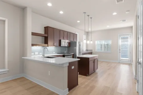 a kitchen with stainless steel appliances granite countertop a sink a stove and a refrigerator