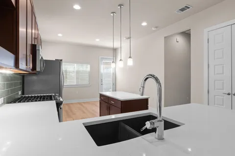 a view of a kitchen with a sink and faucet