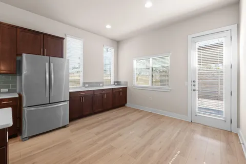 a kitchen with stainless steel appliances granite countertop a refrigerator a sink and a large window