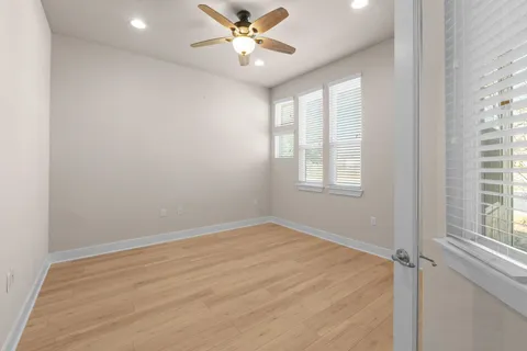 an empty room with windows and fan