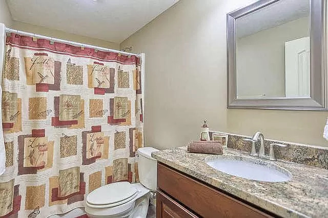 5102 Jacks Boulevard Champaign, IL 61822 - Photo 34 of 36 a bathroom with a granite countertop sink a toilet and shower curtain