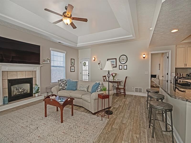 232 Adams Pointe Boulevard, Unit 6 Mars, PA 16046 - Photo 3 of 27 a living room with furniture a fireplace and a flat screen tv