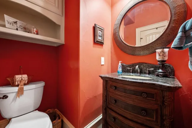 a bathroom with a toilet a sink and a mirror