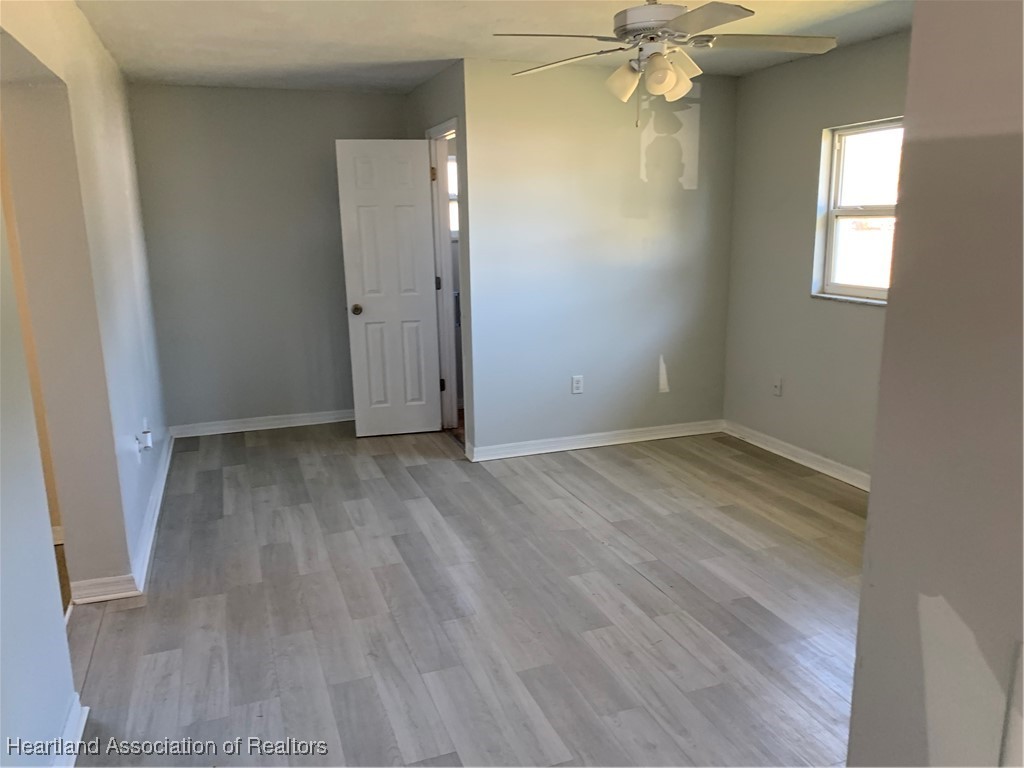 6101 Edgewater Terrace Sebring, FL 33876 - Photo 4 of 10 an empty room with wooden floor and windows