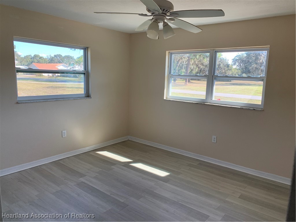 6101 Edgewater Terrace Sebring, FL 33876 - Photo 7 of 10 a view of an empty room with wooden floor and window