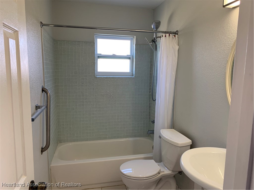 6101 Edgewater Terrace Sebring, FL 33876 - Photo 8 of 10 a bathroom with a toilet bathtub window and shower