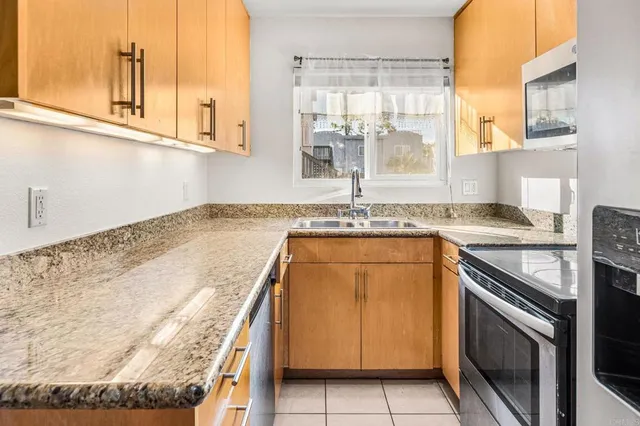 a kitchen with granite countertop a sink and a stove