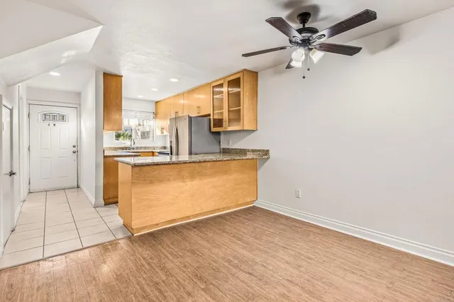 a view of a kitchen with wooden floor and a ceiling fan