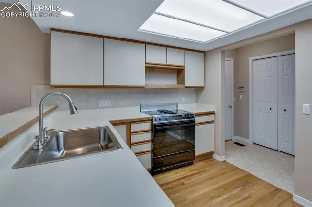 a kitchen with stainless steel appliances a sink stove and cabinets
