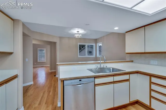 a kitchen with a sink cabinets and wooden floor