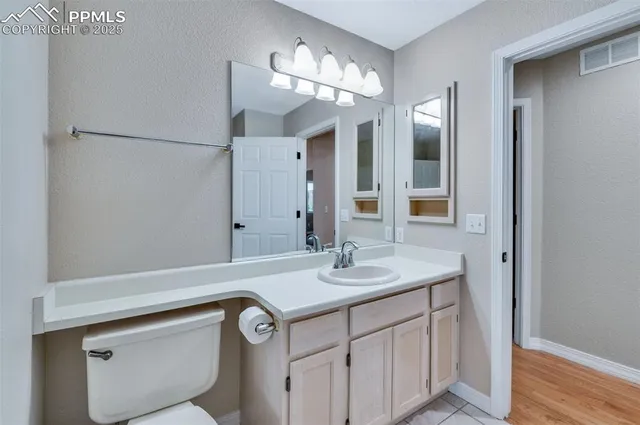 a bathroom with a sink a light fixture and a mirror