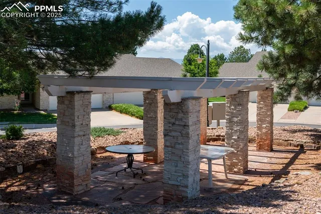 a front view of a house with a yard fountain and large tree