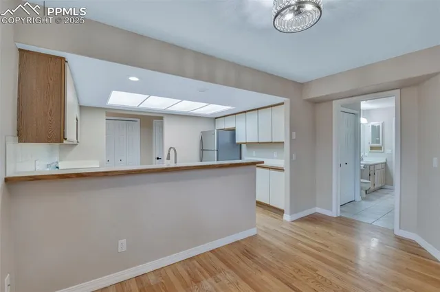 a view of a kitchen with wooden floor and a sink