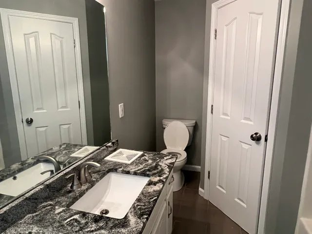 a bathroom with a granite countertop sink and a mirror