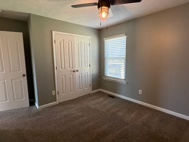 an empty room with windows and closet area