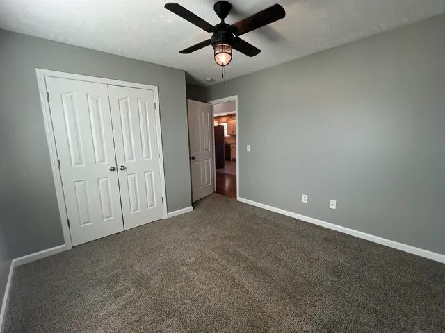 an empty room with closet and windows