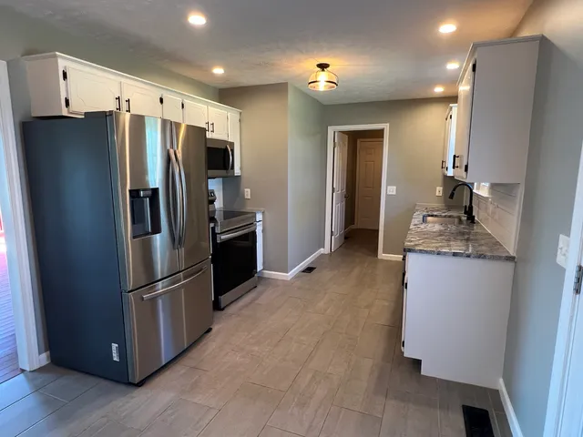 a kitchen with stainless steel appliances granite countertop a refrigerator and a refrigerator