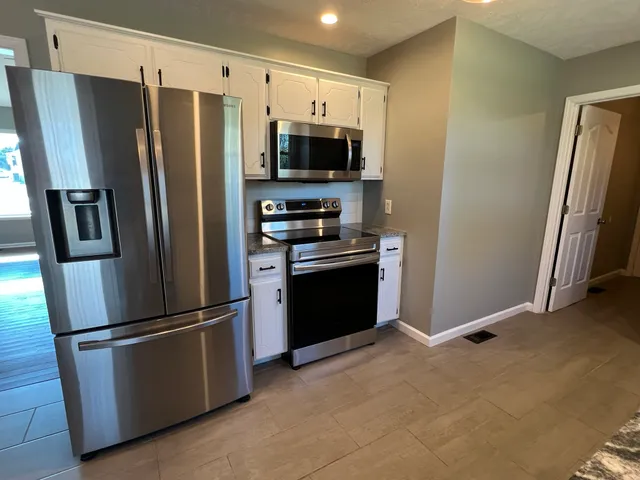 a kitchen with stainless steel appliances and refrigerator