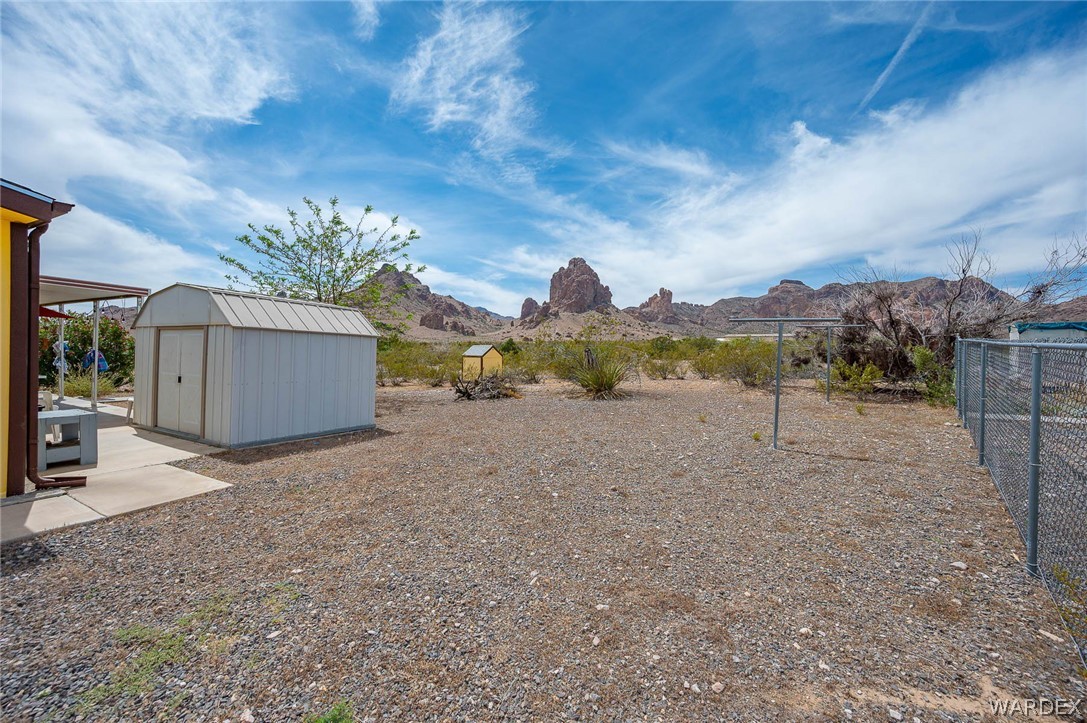 2465 Egar Road Golden Valley, AZ 86413 - Photo 51 of 98 The property features a spacious gravel yard with a storage shed and a clothesline