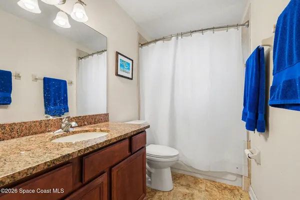 a bathroom with a granite countertop sink toilet and shower