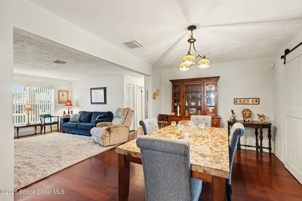 a living room with furniture a chandelier and a window