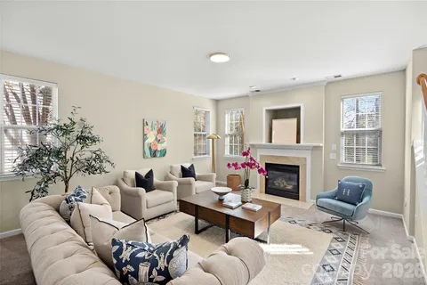 a living room with furniture fireplace and a window