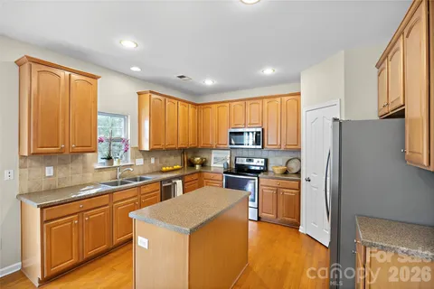 a kitchen with stainless steel appliances granite countertop a refrigerator stove microwave and sink