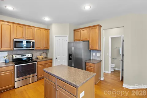 a kitchen with stainless steel appliances granite countertop a refrigerator and a stove top oven