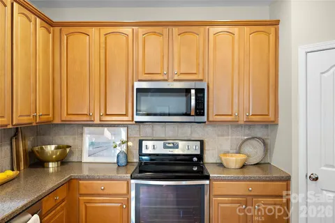 a kitchen with granite countertop a stove sink and cabinets