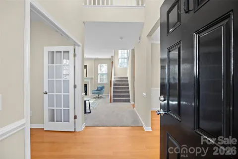 a view of a hallway with wooden floor and bathroom