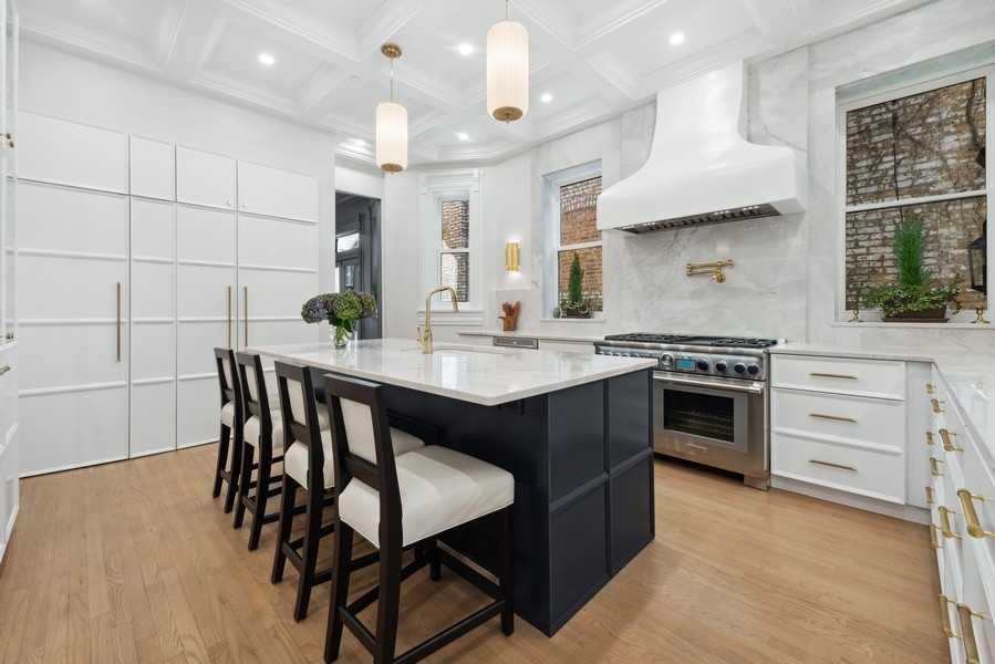 19 East Goethe Street Chicago, IL 60610 - Photo 16 of 46 a kitchen with a stove a sink a dining table and chairs