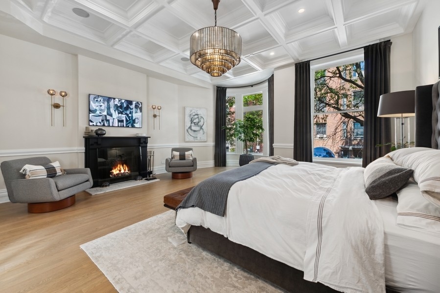 19 East Goethe Street Chicago, IL 60610 - Photo 26 of 46 a spacious bedroom with a large bed and a fireplace