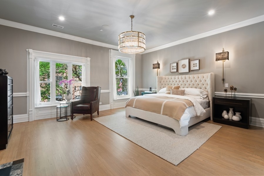 19 East Goethe Street Chicago, IL 60610 - Photo 39 of 46 a bedroom with a bed and a chandelier