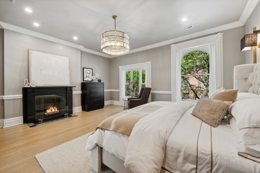 19 East Goethe Street Chicago, IL 60610 - Photo 40 of 46 a bedroom with a bed and a fireplace
