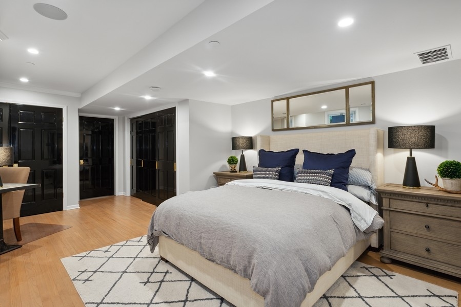 19 East Goethe Street Chicago, IL 60610 - Photo 44 of 46 a spacious bedroom with a bed and a lamp
