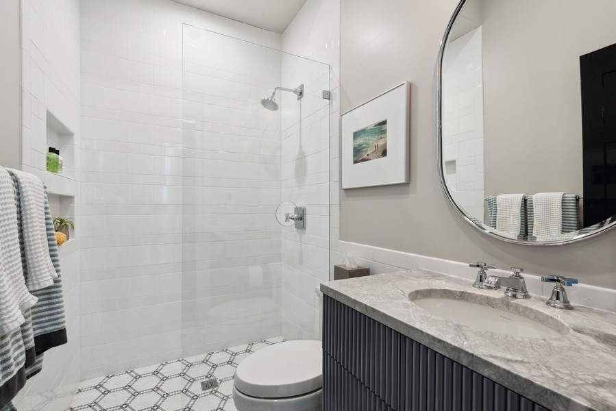 19 East Goethe Street Chicago, IL 60610 - Photo 46 of 46 a bathroom with a granite countertop sink toilet a mirror and shower
