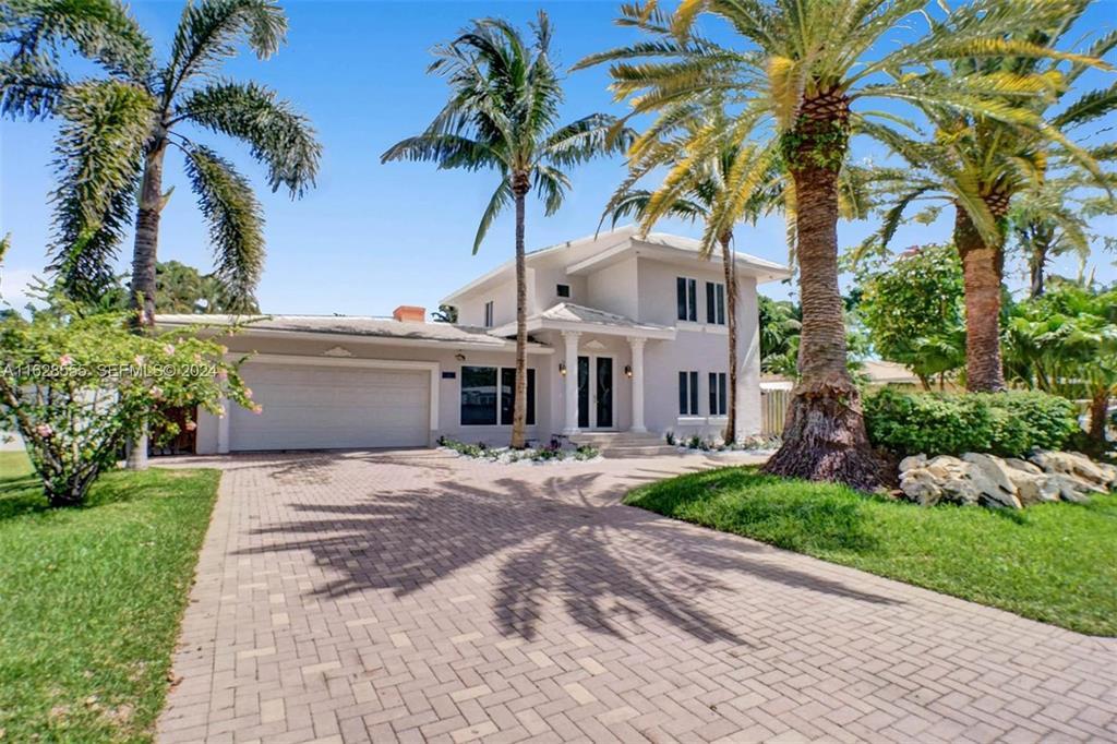 3421 Dover Road Pompano Beach, FL 33062 - Photo 1 of 22 a front view of a house with a garden and trees