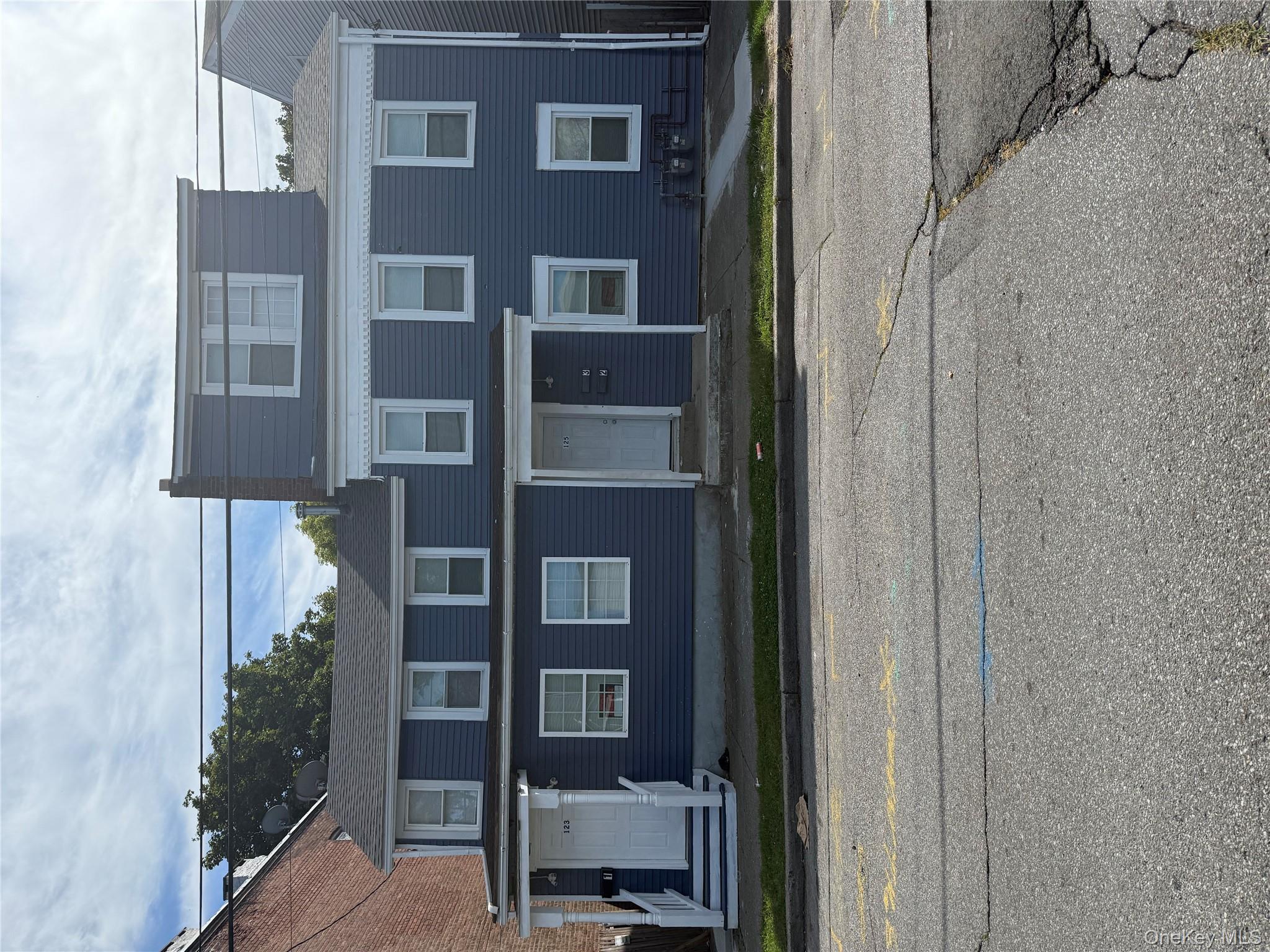 a front view of a residential apartment building with a yard