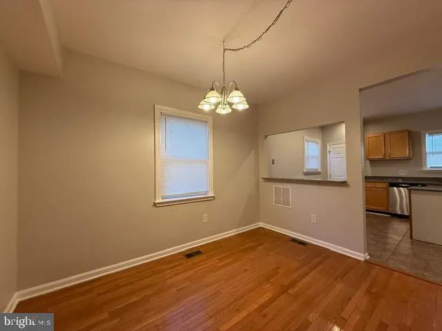 a view of a room with wooden floor and a chandelier